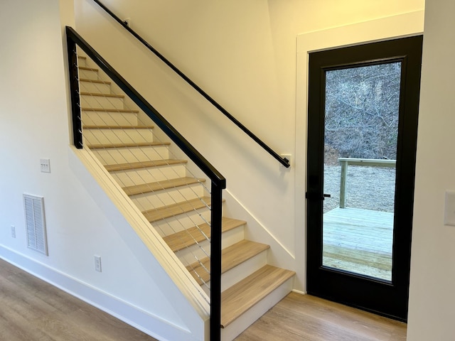 stairs featuring wood-type flooring