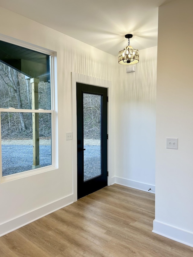 entryway with light hardwood / wood-style floors and a chandelier