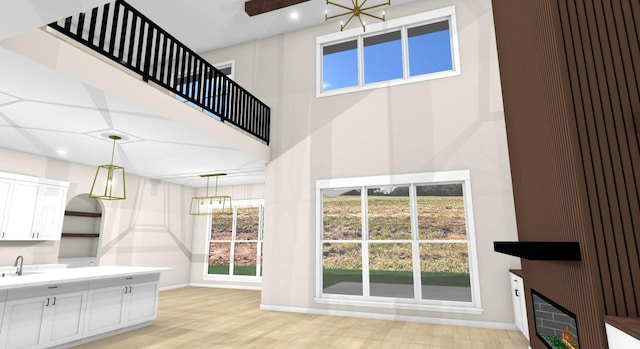 interior space with heating unit, sink, a notable chandelier, and light hardwood / wood-style floors