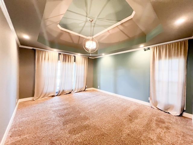 spare room featuring crown molding, a raised ceiling, and carpet flooring