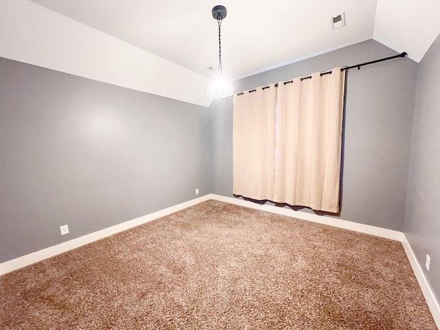 spare room featuring carpet flooring and vaulted ceiling