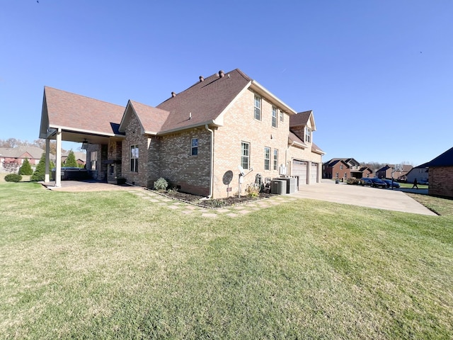 back of property featuring a garage, central AC, and a lawn