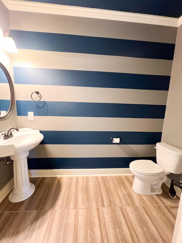 bathroom featuring crown molding and toilet