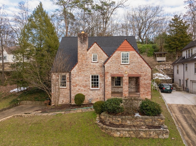 tudor-style house with a front yard and a garage