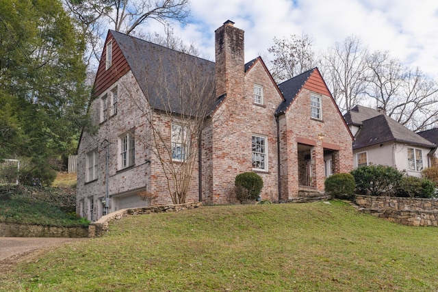 english style home with a front lawn and a garage