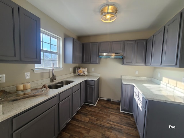 kitchen featuring sink, dark wood-type flooring, light stone counters, and gray cabinetry