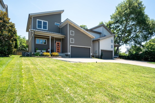 modern home with a front yard, driveway, an attached garage, and fence