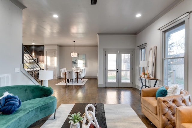 living room featuring french doors, plenty of natural light, wood finished floors, and crown molding