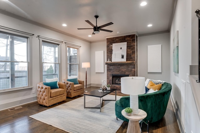 living room featuring recessed lighting, a fireplace, wood finished floors, baseboards, and crown molding