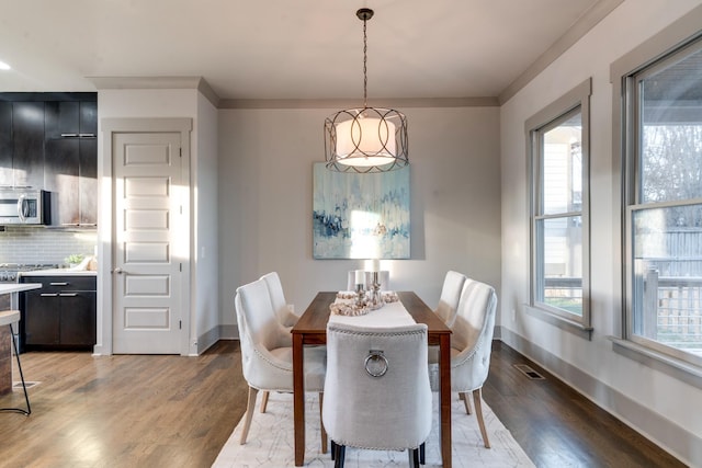 dining room featuring light wood-style floors, visible vents, and baseboards