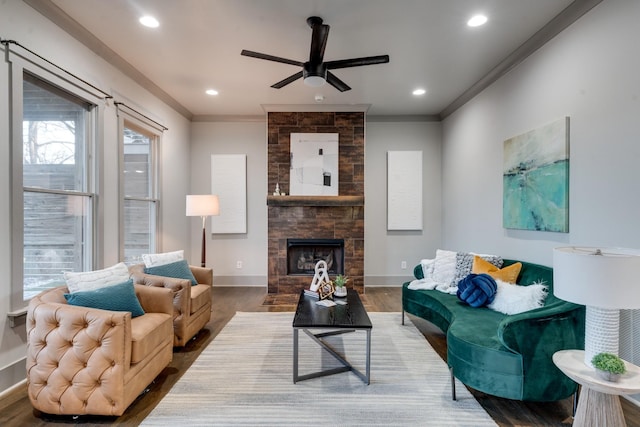 living area with recessed lighting, a fireplace, crown molding, and baseboards