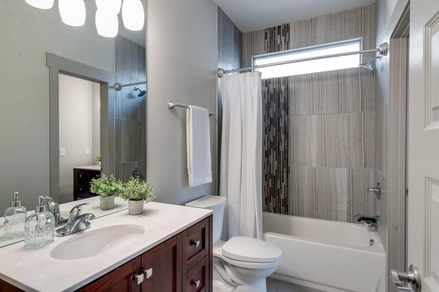 bathroom featuring toilet, shower / bath combo with shower curtain, and vanity