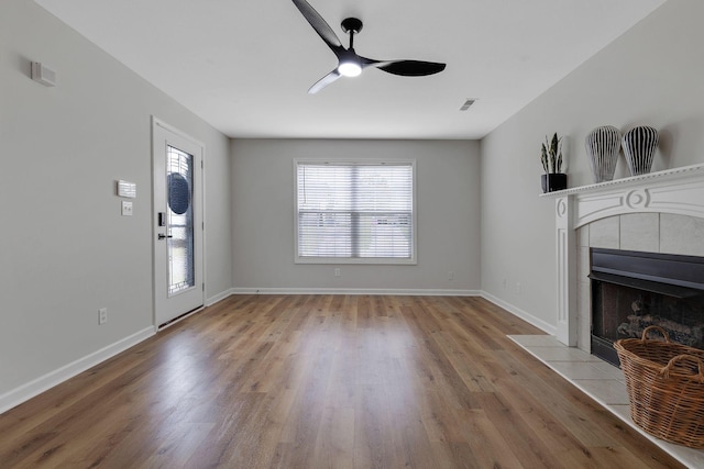 living room featuring a fireplace, ceiling fan, and light hardwood / wood-style flooring