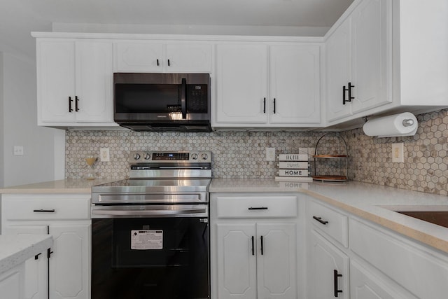 kitchen featuring decorative backsplash, white cabinetry, and appliances with stainless steel finishes