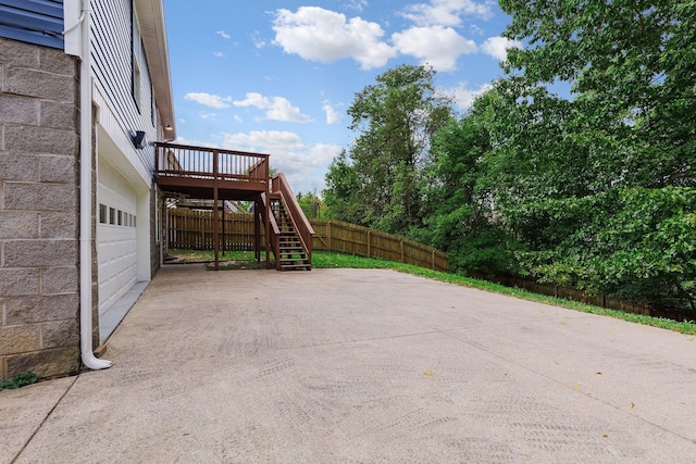 view of patio featuring a garage and a wooden deck