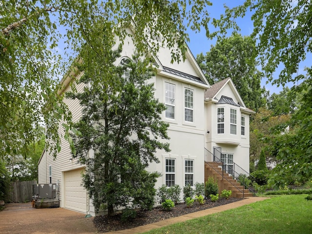 view of home's exterior with central AC and a garage