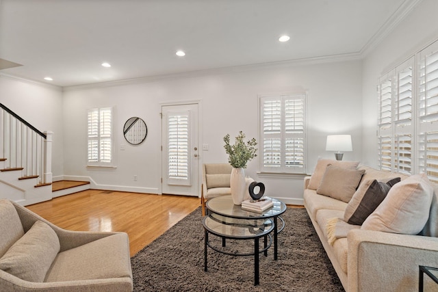 living room with a healthy amount of sunlight, ornamental molding, and wood-type flooring