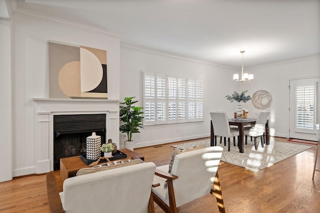 living room featuring ornamental molding, light hardwood / wood-style flooring, and a chandelier