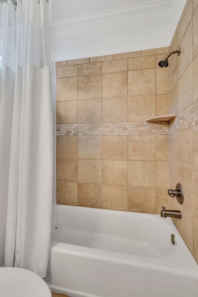 bathroom featuring toilet, crown molding, and shower / bath combo with shower curtain