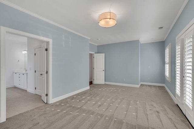 empty room with light colored carpet and crown molding