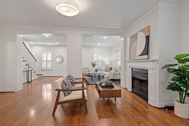 living room with light wood-type flooring, plenty of natural light, and crown molding