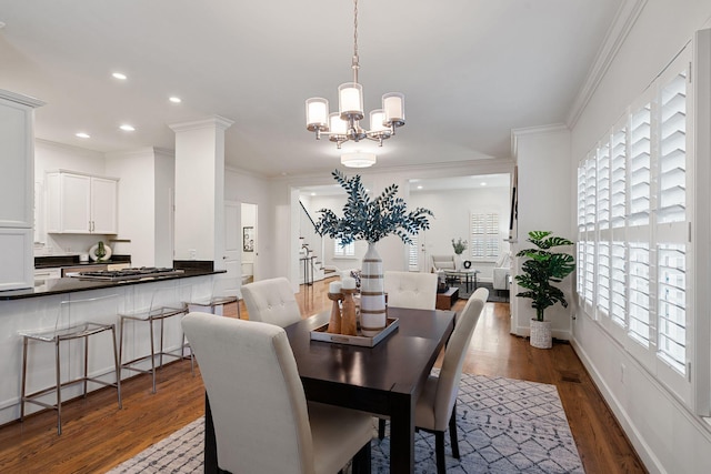 dining room with dark hardwood / wood-style flooring, a notable chandelier, and crown molding