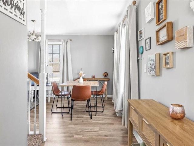 dining room featuring light wood-type flooring and an inviting chandelier