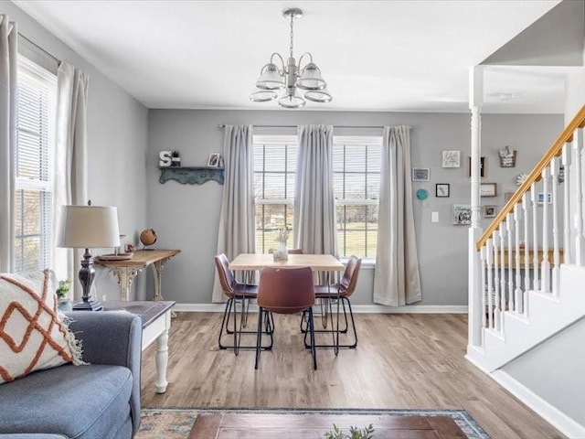 dining area with a healthy amount of sunlight, light hardwood / wood-style flooring, and a chandelier