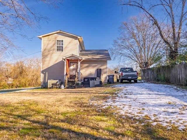 rear view of property featuring a lawn