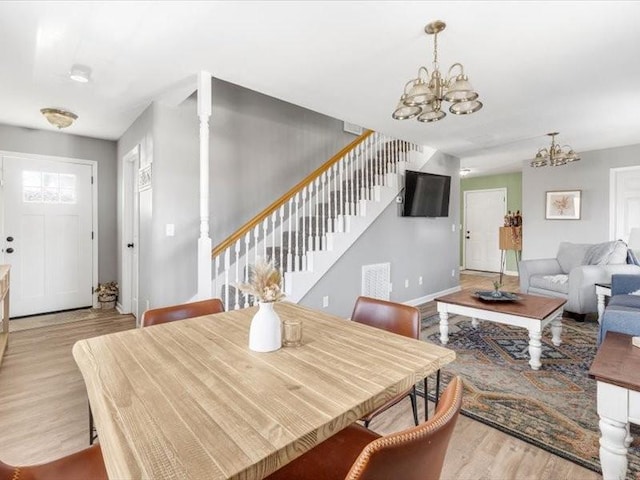 dining room with a notable chandelier and light hardwood / wood-style flooring