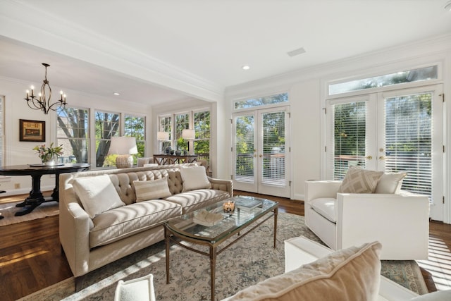 sunroom / solarium with a wealth of natural light, french doors, and an inviting chandelier