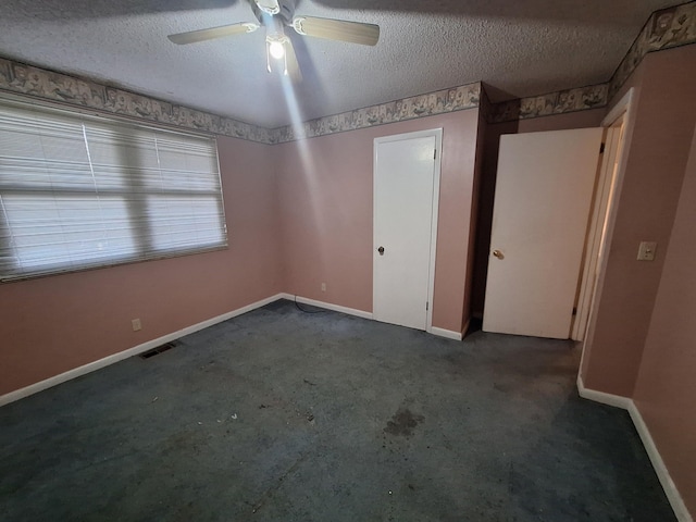 carpeted spare room featuring ceiling fan and a textured ceiling