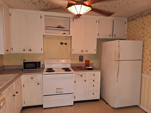 kitchen with ceiling fan, sink, white appliances, and white cabinets