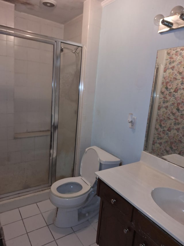 bathroom with a shower with shower door, vanity, tile patterned floors, and toilet