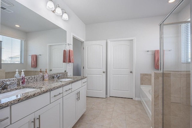 bathroom with tile patterned flooring, shower with separate bathtub, and vanity