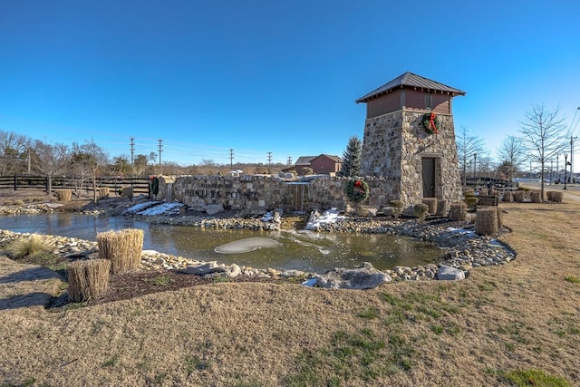 view of community featuring a garden pond