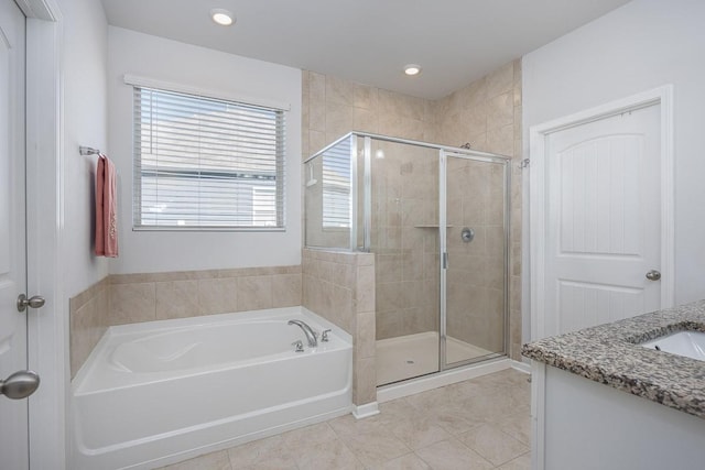 bathroom with vanity, tile patterned flooring, and plus walk in shower