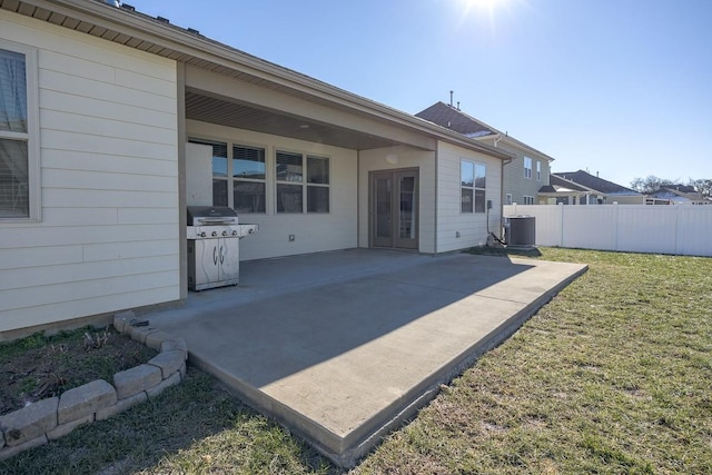 rear view of house featuring a patio area, central AC, and a yard