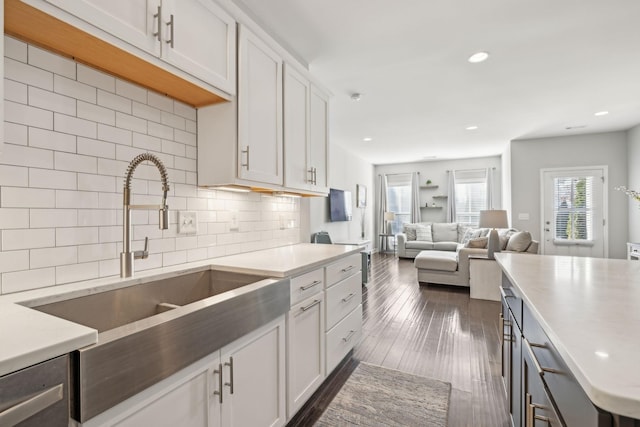 kitchen with decorative backsplash, sink, and white cabinetry