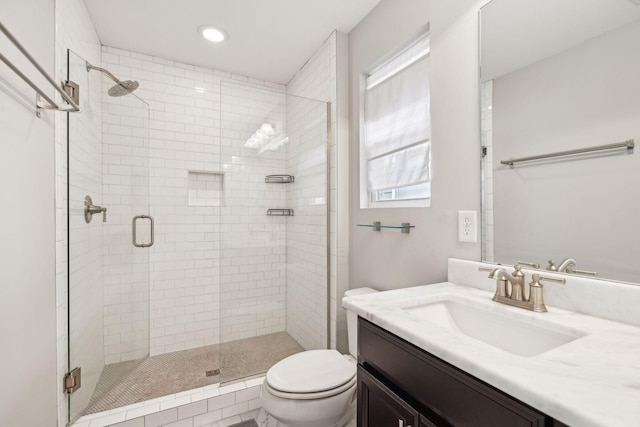 bathroom with toilet, vanity, and walk in shower