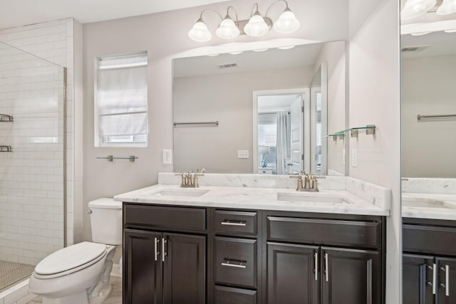 bathroom with toilet, plenty of natural light, an enclosed shower, and vanity