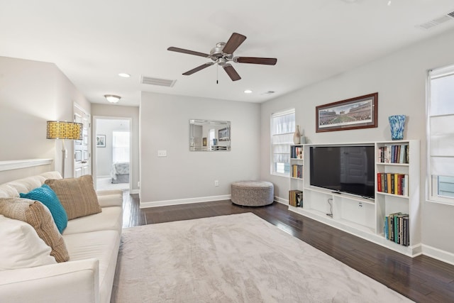 living room with ceiling fan and dark hardwood / wood-style flooring