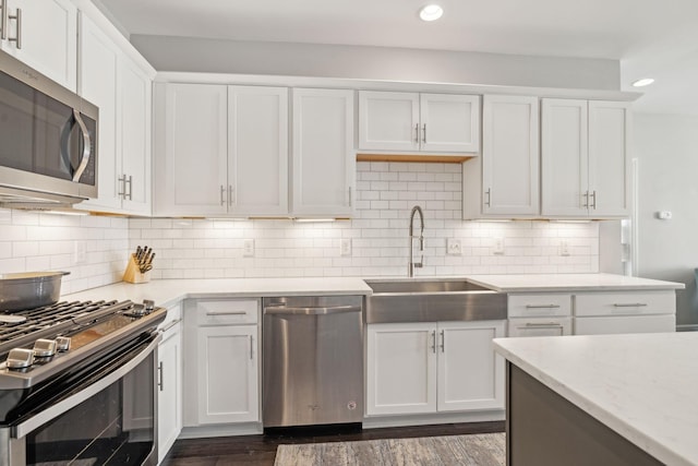 kitchen featuring sink, white cabinetry, appliances with stainless steel finishes, and dark hardwood / wood-style floors