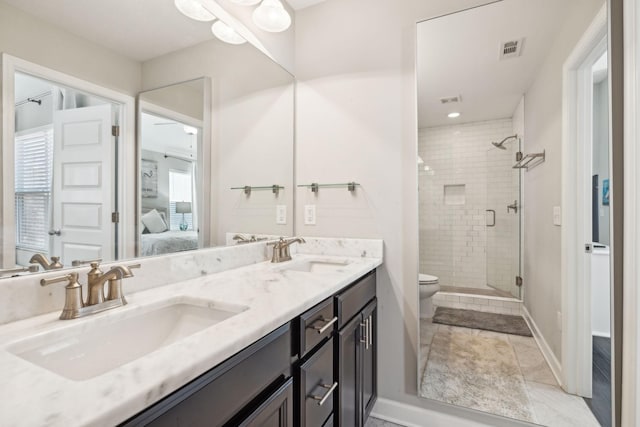 bathroom featuring toilet, a shower with shower door, and vanity