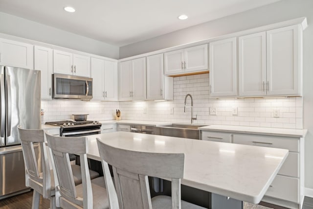 kitchen with white cabinets, dark hardwood / wood-style flooring, sink, and stainless steel appliances