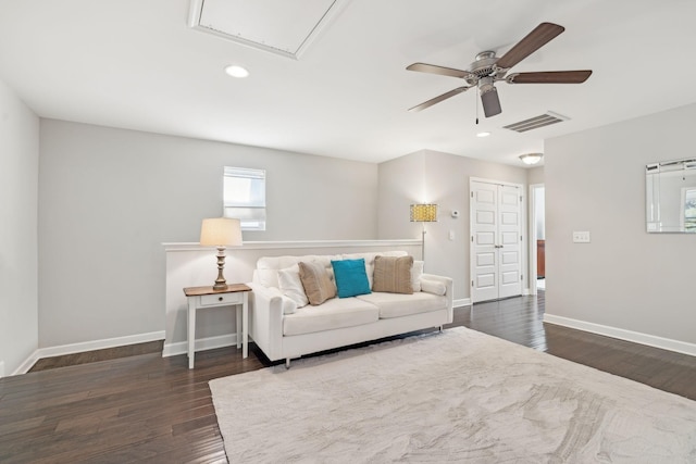 living room with ceiling fan and dark wood-type flooring