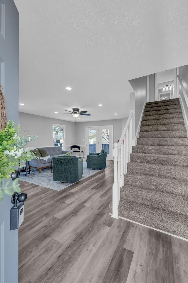 stairway featuring french doors, ceiling fan, and hardwood / wood-style flooring