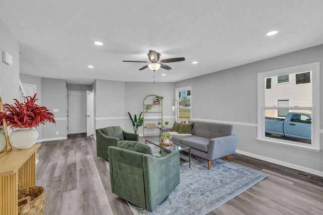 living room featuring ceiling fan and hardwood / wood-style flooring