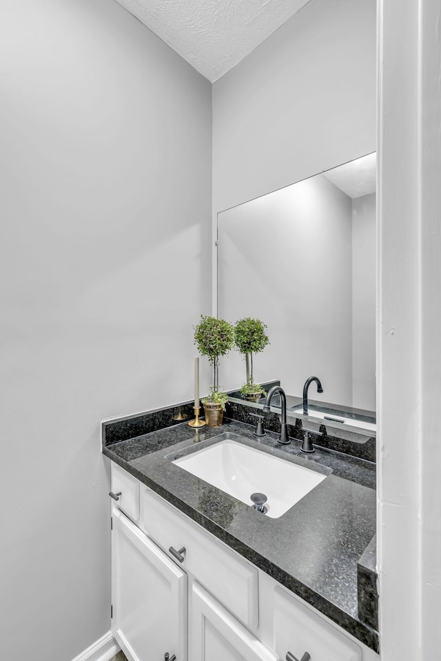 bathroom featuring a textured ceiling and vanity