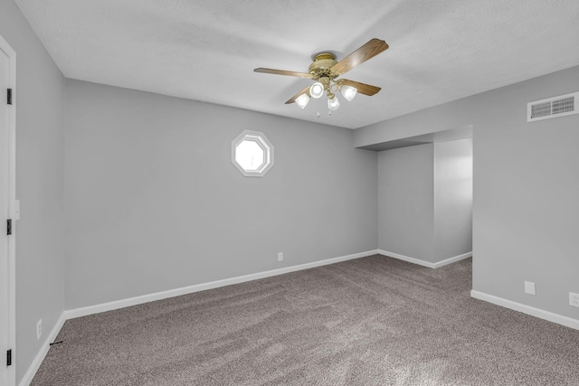 carpeted spare room featuring a textured ceiling and ceiling fan